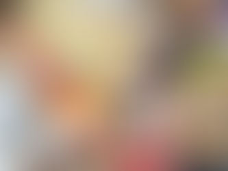 A customer tapping a credit card on a payment terminal held by a smiling cashier at a grocery market.