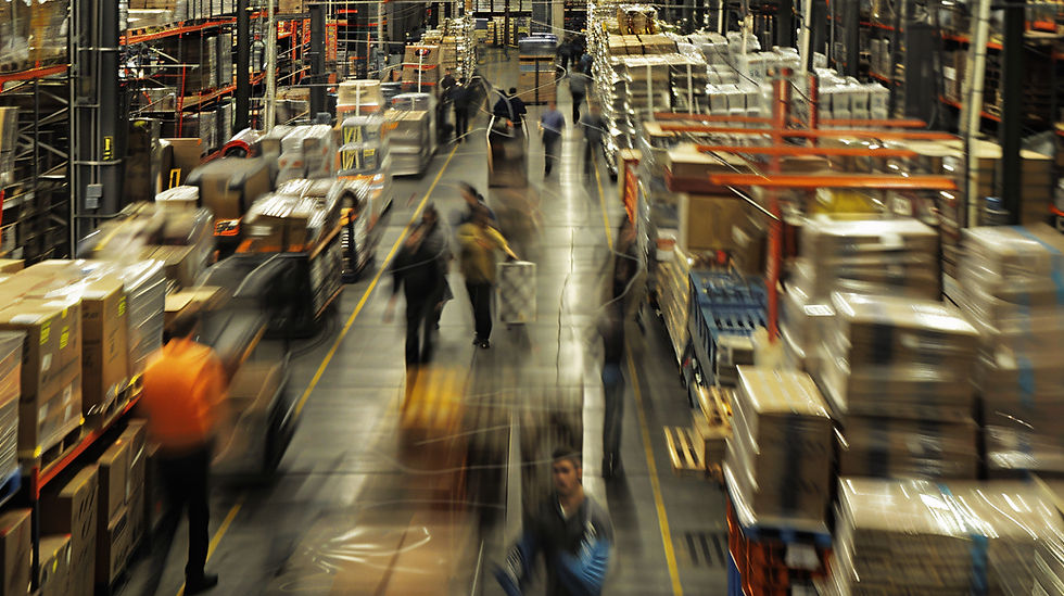 A bustling warehouse with temporary employees walking through the main aisle, illustrating on-demand staffing support, workforce flexibility, and reliable staffing agency solutions.