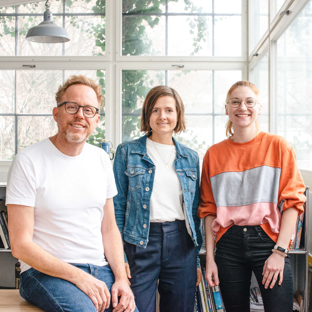 Yulis Team steht vor einem Fenster