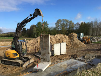 Ein Krahn hebt ein Betonfundament an