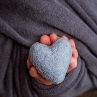 Close-up of a soft blue heart prop held by newborn baby Eliab during Aurora newborn photography session