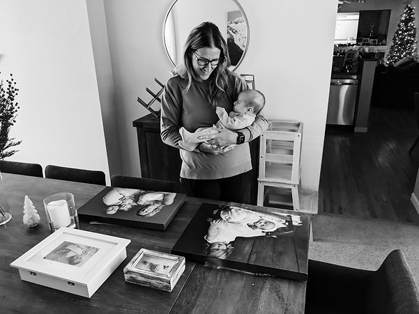 Styled newborn photography studio workspace with printed images and floral details