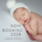 Newborn baby peacefully sleeping on a black backdrop, posed with hands under cheek and legs tucked in, wearing a delicate black headband with soft curls of dark hair.