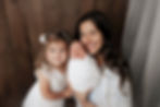Aurora Colorado | Newborn Photographer | Tiny Details Photography | Newborn baby boy wrapped in a gray potato style lying in sisters arms embraced for a hug while sister wears beautiful ivory lace dress both are lying on gray fur flokati