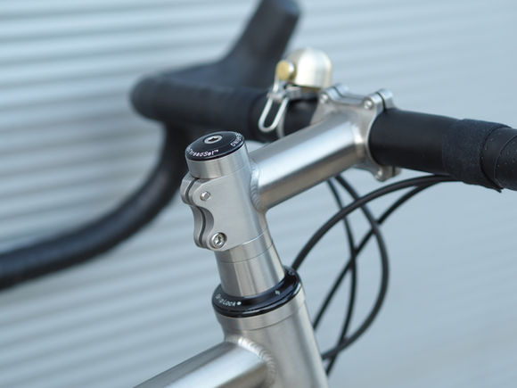 Close-up of Nua titanium stem with hand-brushed finish and ±6° angle, highlighting craftsmanship and precision.