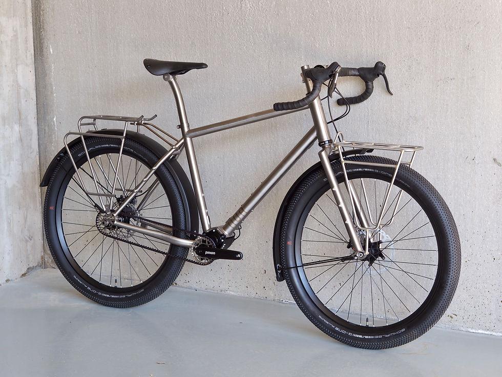 Nua Terra Pinion bikepacking build captured at our workshop before shipping it out to Casey, featuring a titanium all-terrain frame, Pinion P1.18 gearbox, 27.5+ tires and integrated racks - designed for adventure cycling and long-distance touring.