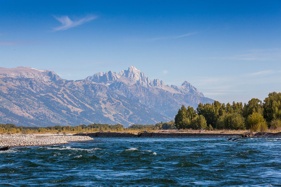 On the snake river with the Tetons in the background and a blue sky