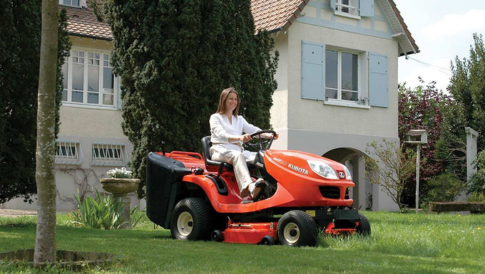 A woman driving a ride-on lwanmower hored from Stubbings Bros Ltd