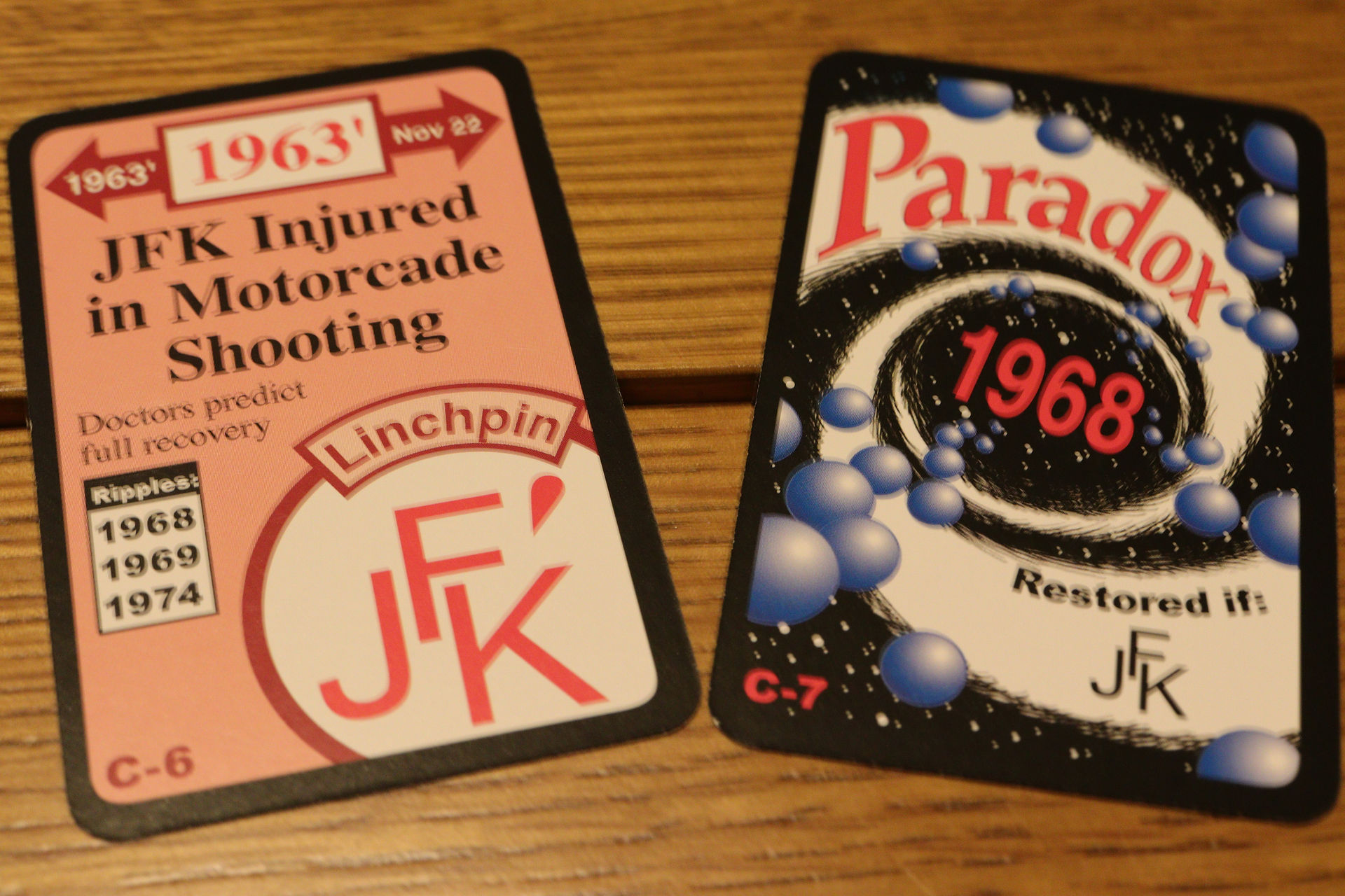 Example cards from the game Chrononauts showing a linchpin cards on the alterative side and the paradox it creates