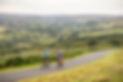 Couple cycling along a scenic road through the North York Moors countryside near Ainthorpe and Whitby