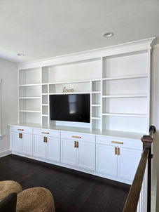 White custom built-in entertainment center with shelving and storage installed in Moncks Corner, SC living room.