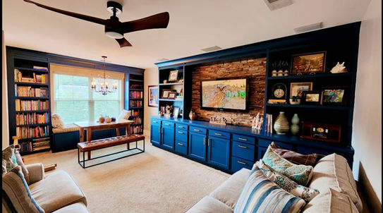 Custom built-in entertainment center with shelving and stone accent wall installed in Charleston, SC living room.
