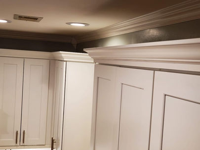 Custom crown molding installation above white cabinetry in Summerville, SC kitchen.