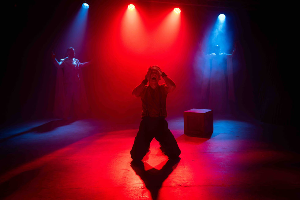 Cast member on there knees in red and blue lighting