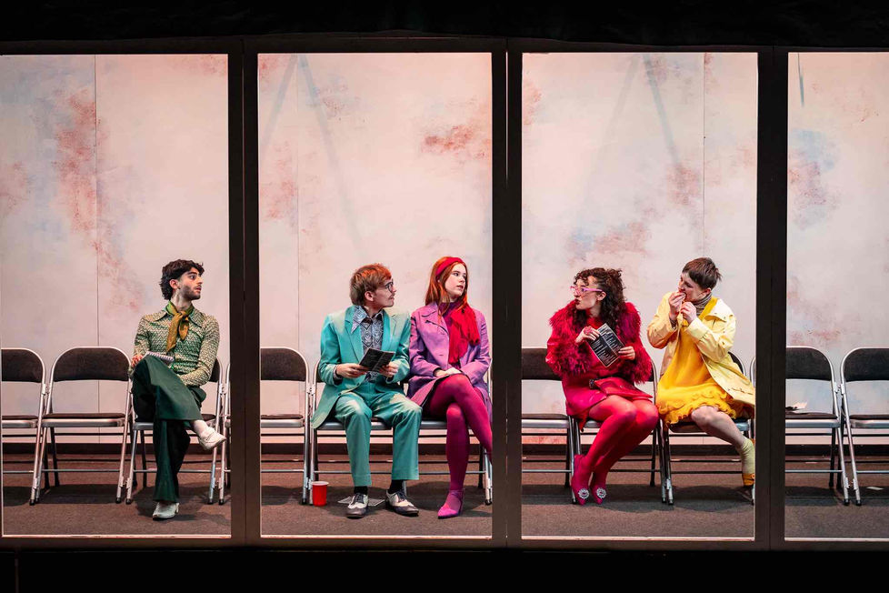 Characters at the 'cinema' dressed in bright colours