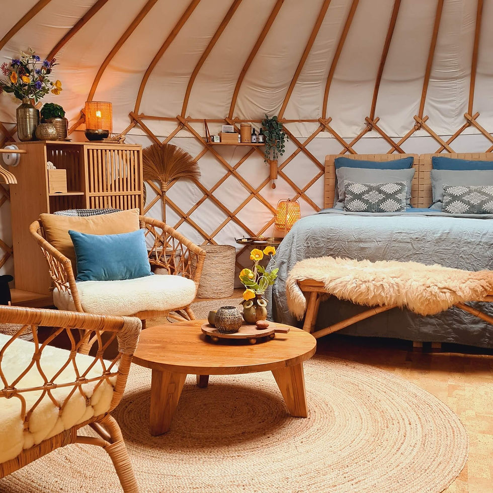 Binnenkijkje in yurt Orion – zithoek en bed met warme styling en ronde lijnen