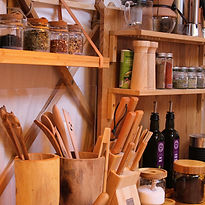 Keukendetails met assortiment thee, scherpe messen, kruiden, specerijen en olie voor koken in de yurt.