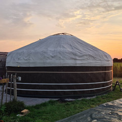 Yurtbouw met buitenste canvasdoek gespannen om het dakframe, laatste laag van de duurzame Kirgizische yurtconstructie.