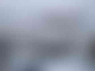 Besneeuwd terras met weids uitzicht, winterse rust rondom de yurt met een warm toevluchtsoord binnen.