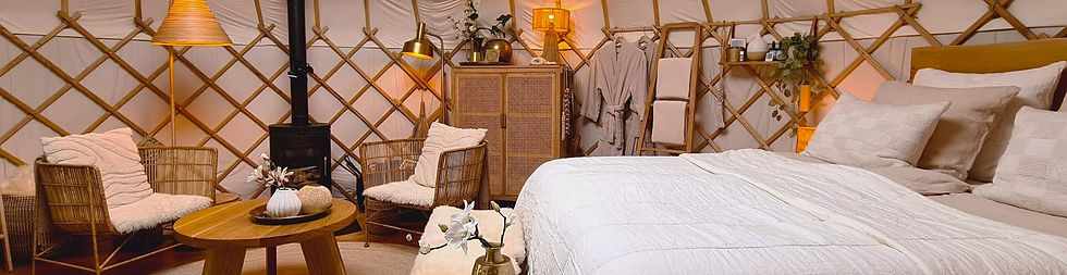 Yurt Sirius – bed en zithoek vanaf de zijkant, warme inrichting voor een originele overnachting in de natuur