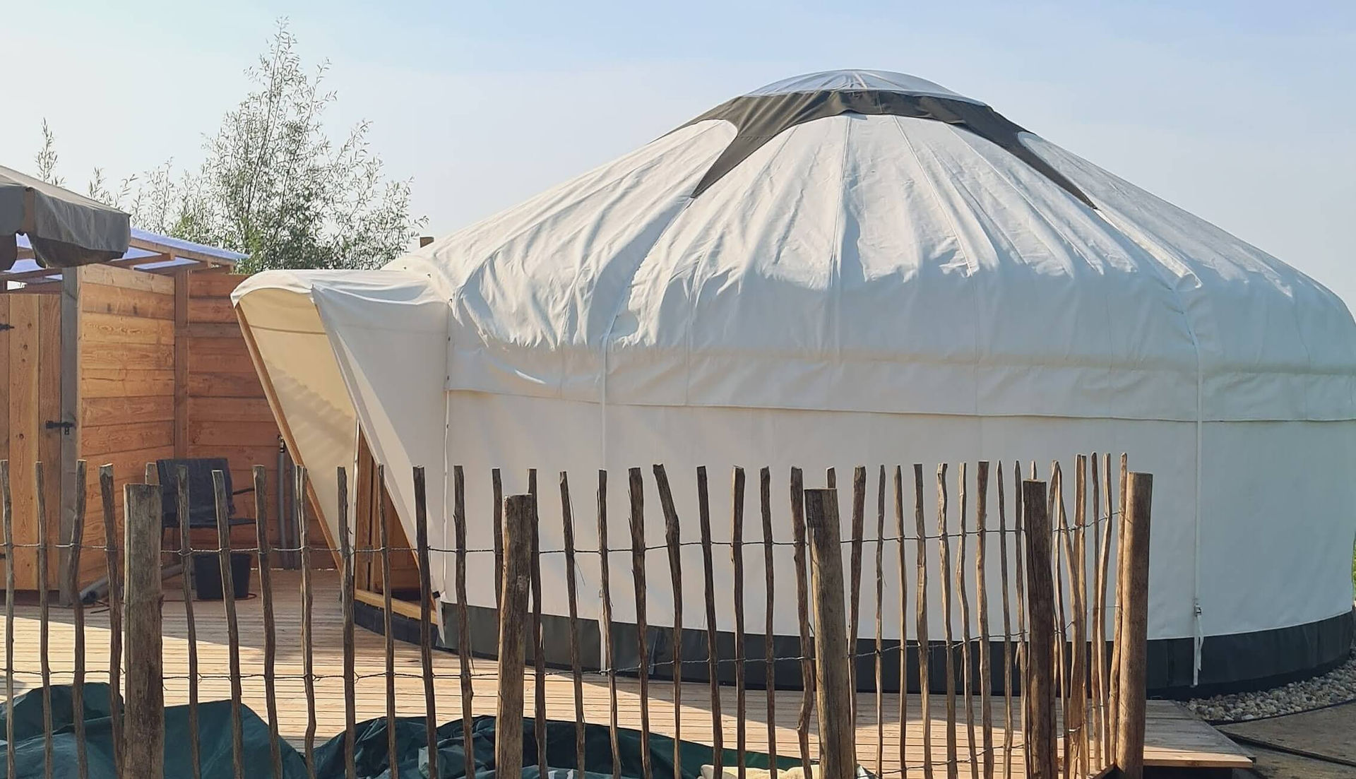 Bekleding over dak en wanden met transparante starcap bovenop de yurt, waardoor daglicht blijft binnenvallen.
