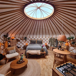 Yurt Orion interieur met kleurrijke details en speelse energie, sfeervol natuurverblijf.