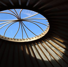 Namiddaglicht valt door de kroon van de yurt en geeft het interieur een warme sfeer.