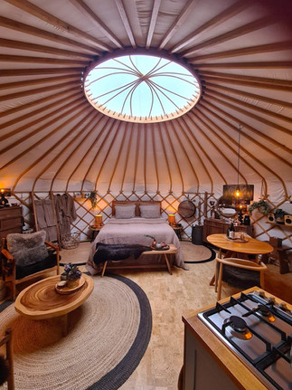 Yurt Venus - groothoekbeeld van een ronde ruimte met warmte, eenvoud en geborgenheid.