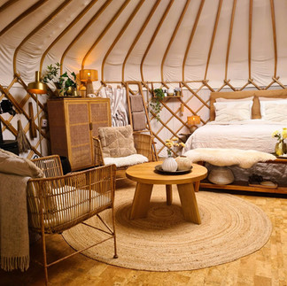 Yurt Sirius gezien vanaf de deur met bed en zithoek in rustige wintersfeer.