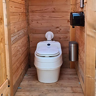 De toiletruimte met modern droogtoilet van Separett, dat er uit ziet als een gewoon toilet.