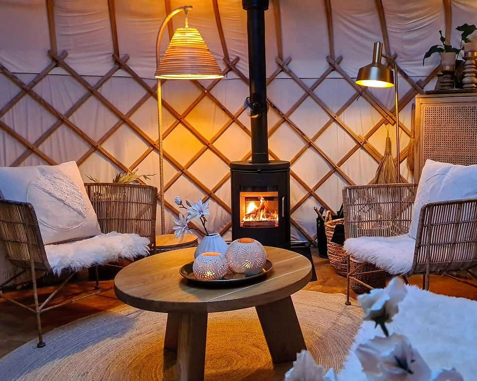 Brandende houtkachel in yurt Sirius met sfeerverlichting – ultieme warmte bij winterglamping