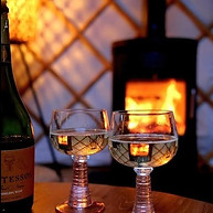 Twee glazen cava bij de houtkachel voor een romantische overnachting in de yurt.