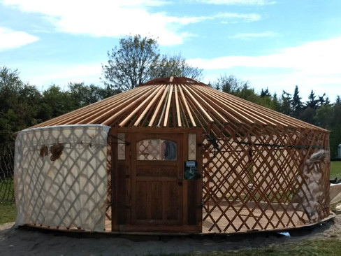 Geraamte van een Mongoolse ger met doek, rechte dakstokken en pilaren tonen verschil yurt en ger.