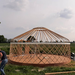 Opbouw Kirgizische yurt: houten vloer en geraamte als basis van een duurzaam bouwwerk in het Achterhoekse landschap.
