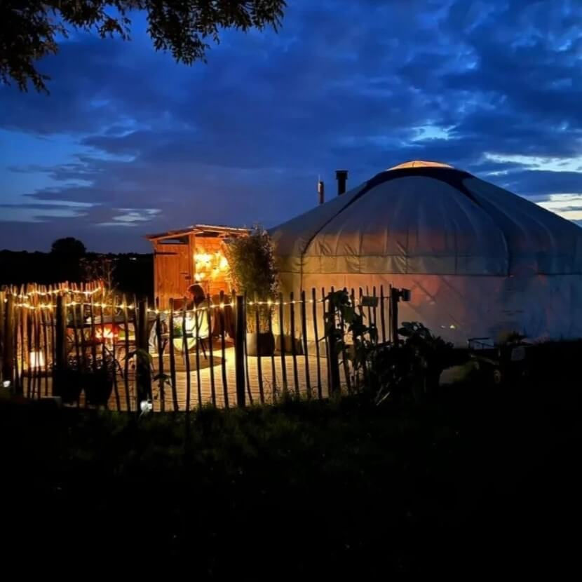 Yurt Orion bij avond met terrasverlichting – romantisch verblijf onder de sterrenhemel