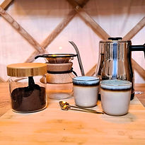 Slow coffee maken in de yurtkeuken met biologische koffie, pour-over koffiemaker en zwanenhals waterkoker in stijlvolle kopjes.