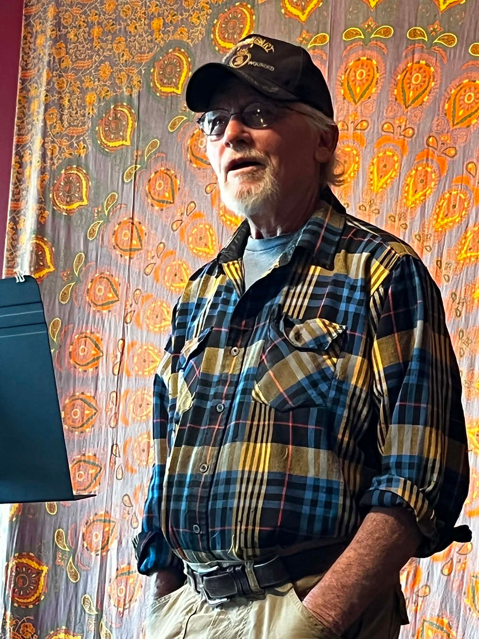 Author and master of ceremonies Charles Kniffin stands before the audience at Lubec Brewing Company, sharing stories and readings during the literary tribute to J.D. Rule and Sineidin O’Niall.