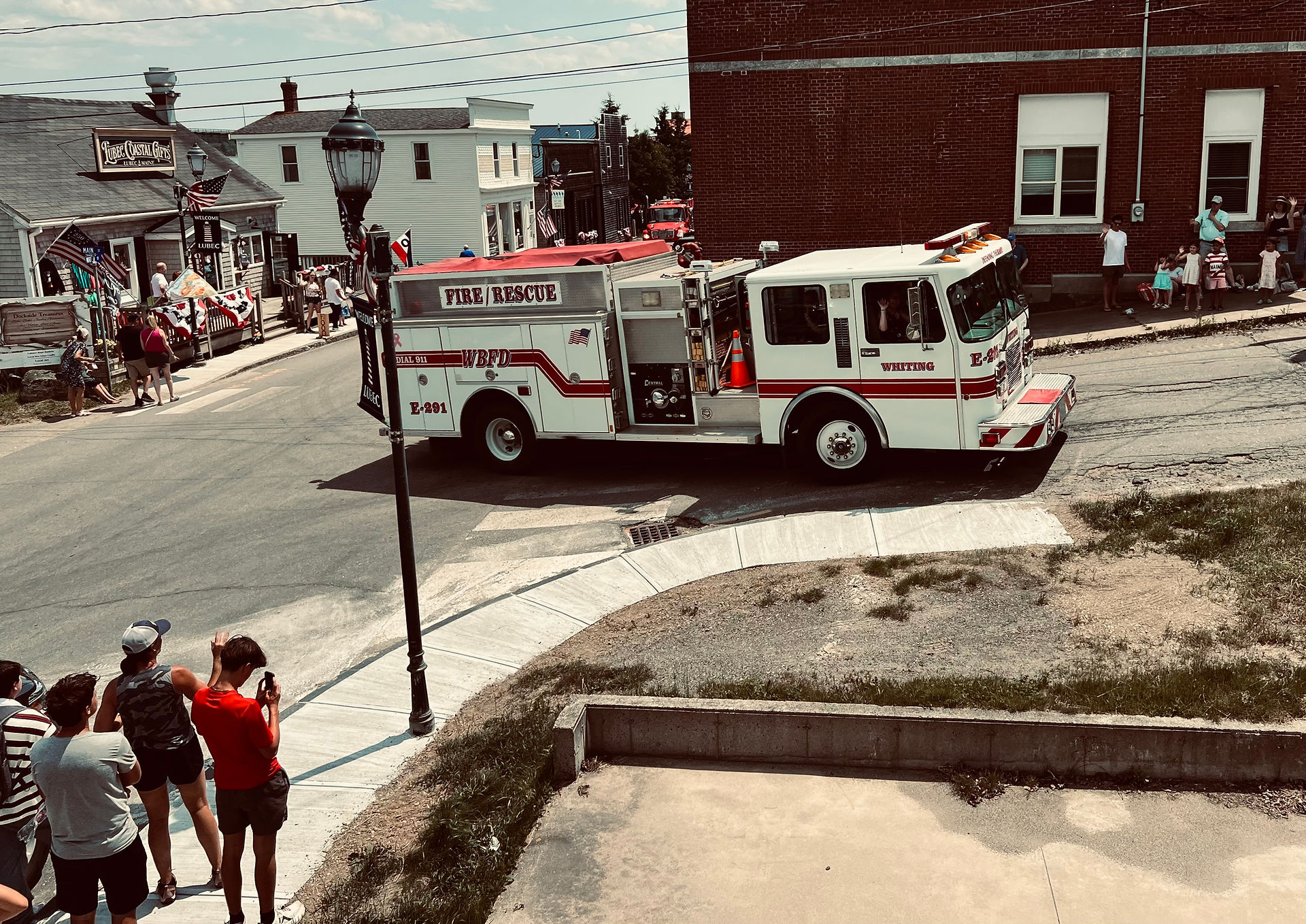 Whiting Fire Rescue engine drives through downtown Lubec during the Fourth of July parade as spectators watch from the sidewalks.