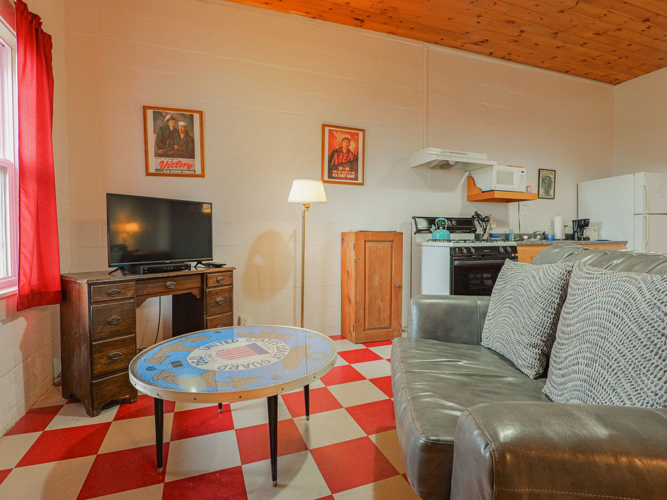 Living room space with couch, coffee table, and TV