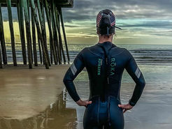 woman in wetsuit standing on beach