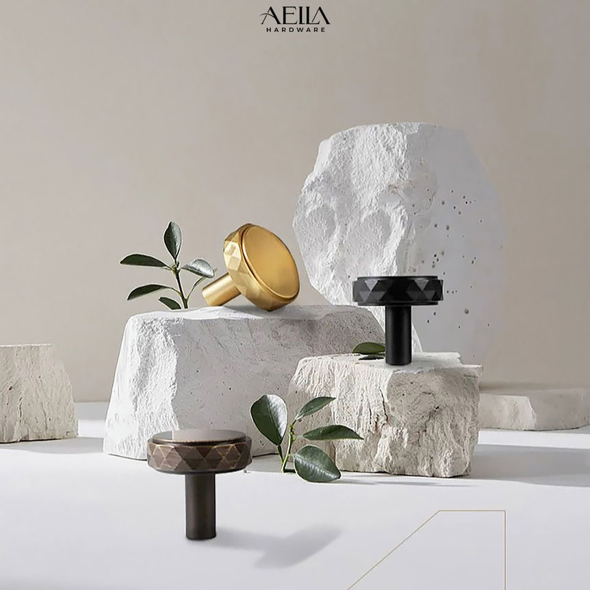 AELLA HARDWARE, gold and black knobs on white stone, minimalist design, elegant. AELLA HARDWARE