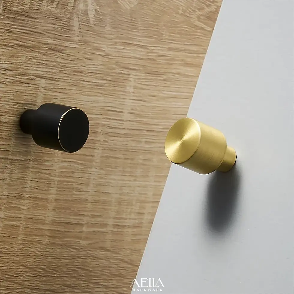 มือจับสีดำและสีทองบนพื้นผิวไม้และผนังสีขาว AELLA HARDWARE สวยงาม