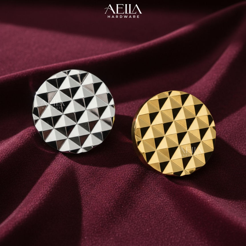 Two metallic circular hardware AELLA HARDWARE on maroon cloth
