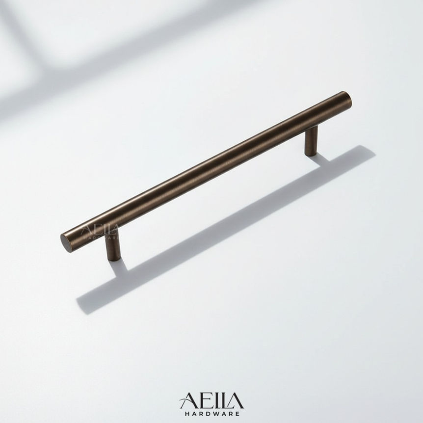 มือจับเฟอร์นิเจอร์แบบยาว สีทองเหลืองวางบนพื้นผิวสีขาว พร้อมเงา AELLA HARDWARE