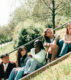 A diverse group of students sitting on stairs and laughing together