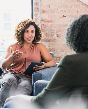 A counselor talking to a woman sitting in front of her
