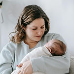 A young mother holds her newborn baby.