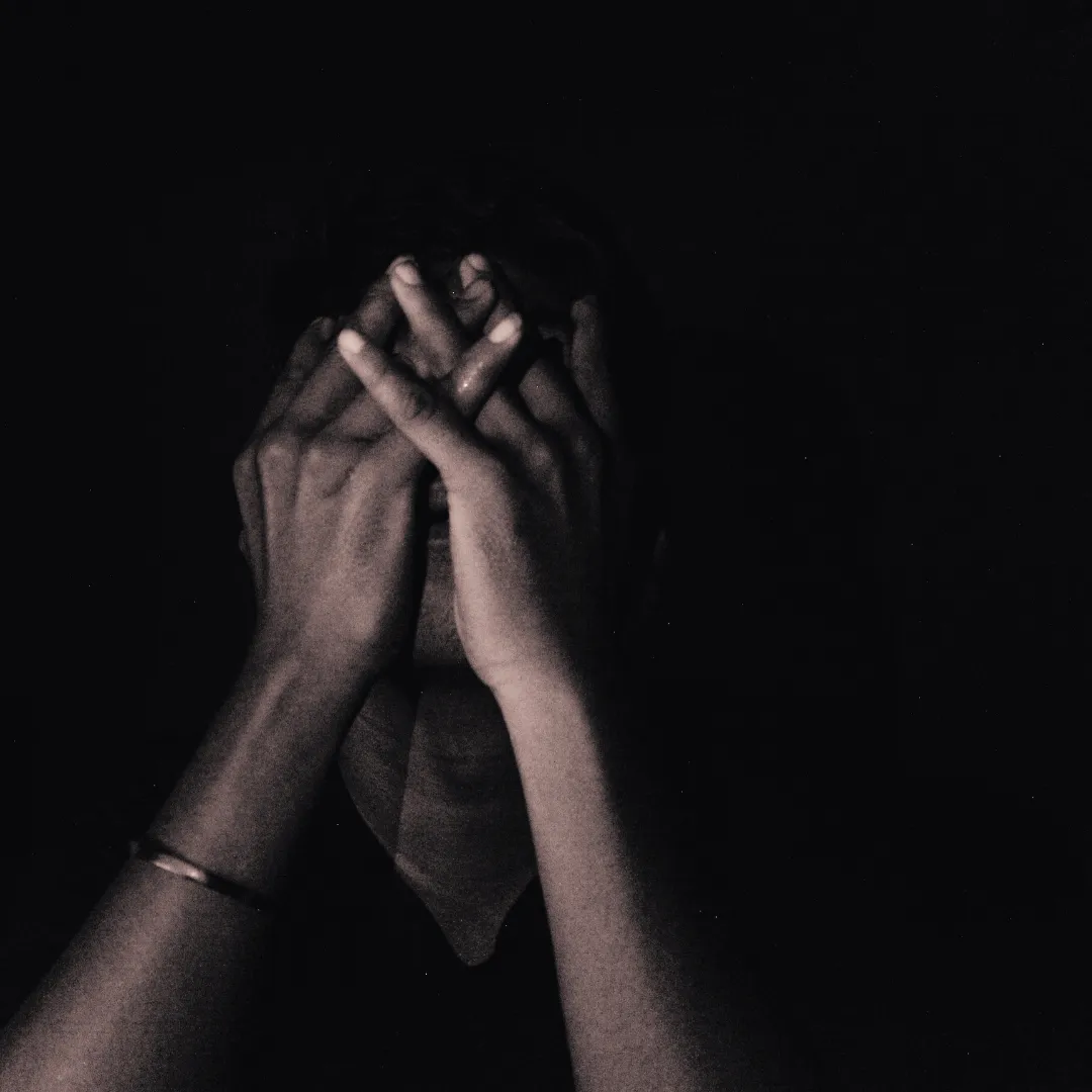 Picture of a depressed woman with her face covered by her hands. IMA ART Luxury Surrogacy program acknowledges the potential of postpartum depression.