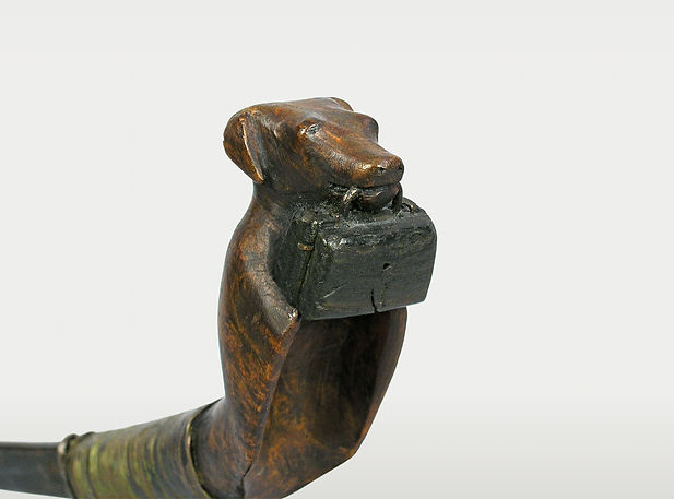 Canadian Maritimes crooked knife (mocotaugan) from circa 1850–1880, featuring a carved wooden handle in the form of a dog holding a doctor's bag.