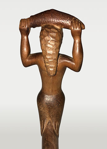 Full body back view of a Mermaid holding a salmon crooked knife, Eastern Woodlands, Maine or Maritime Canada, circa 1920-1940, featuring wood, brass wire, and a repurposed trade blade.